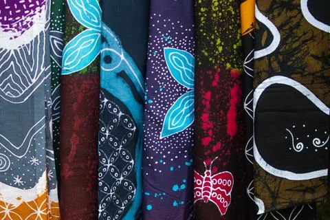 Vertical Stack of Patterned Batik Fabrics in Craft Market Background Stock Photos