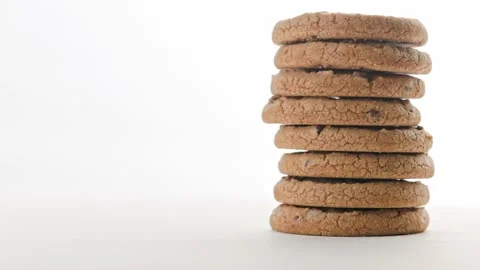 Vertical stack of round chip cake cookies with chocolate on white surface slow Stock Footage 175156976