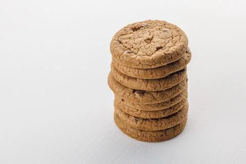 Vertical stack of round chip cake cookies with chocolate on white surface Stock Photos