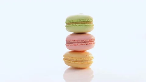 Vertical stack of three macarons against a bright white background. Sweet Stock Footage 194836010