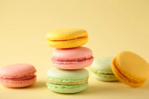 A vertical stack of three macarons on beige background. Sweet dessert 스톡 사진