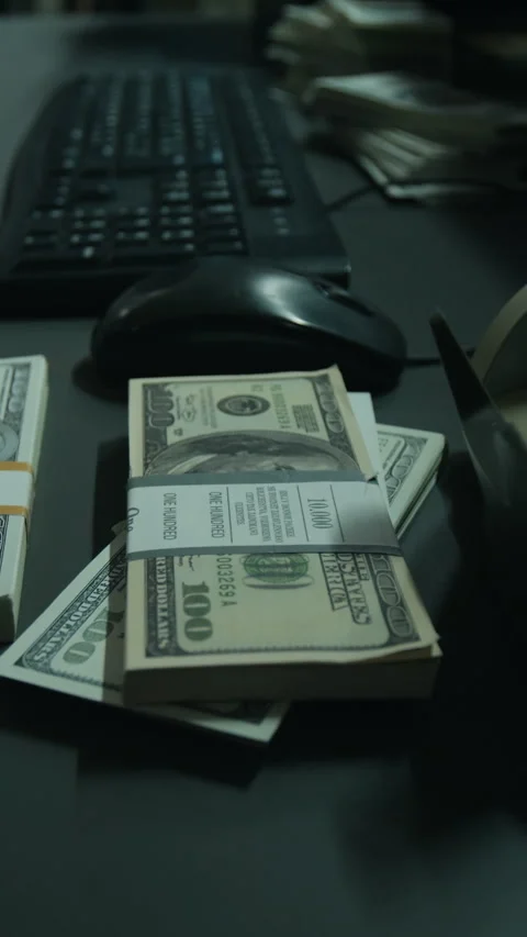 Vertical of Stacks of Hundred Dollar Bills Resting on Desk by Computer Keyboard Vídeos de archivo 346713586