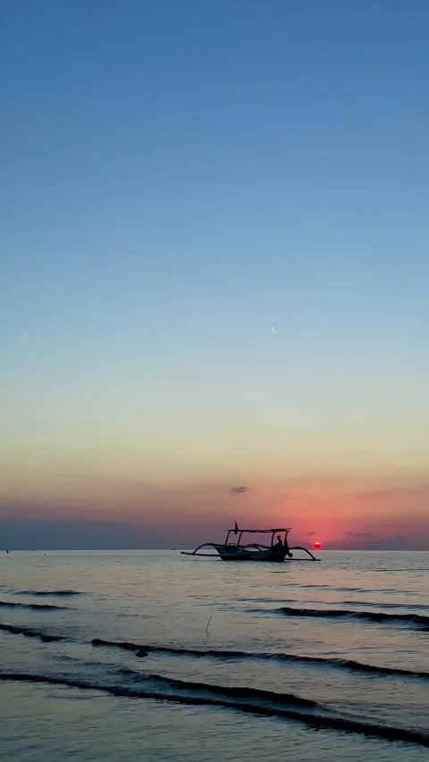 Vertical Static Shot of Bali Boat at Sunset with Airplane Contrail Stock Footage 339276668
