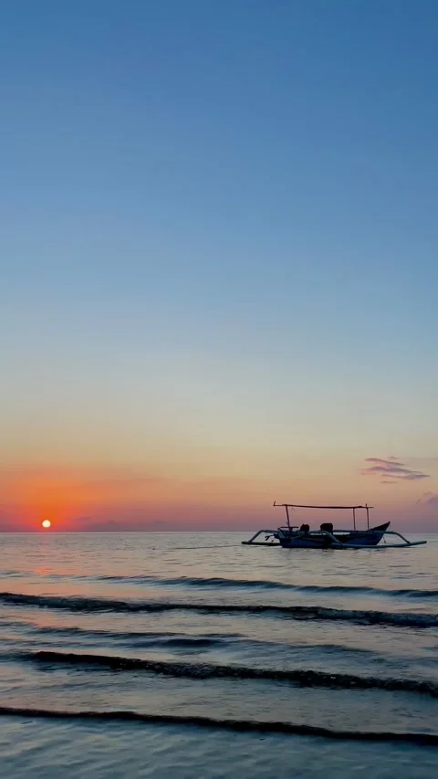Vertical Static Shot of Boat on Calm Sea at Sunset in Bali Stock Footage 339276641