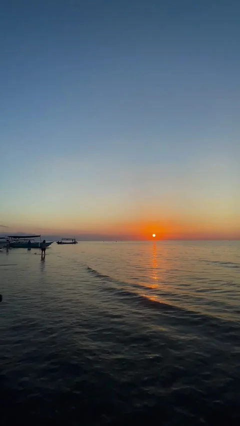 Vertical Static Shot of Golden Ocean Sunset and Boat Silhouette Stock Footage 339276626