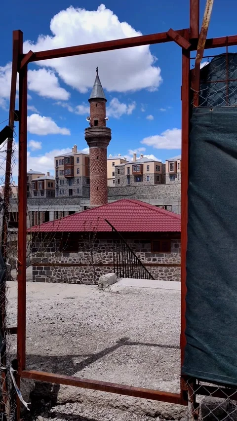 Vertical static shot of a historical mosque minaret framed by a rustic metal Vídeos de archivo 333908365