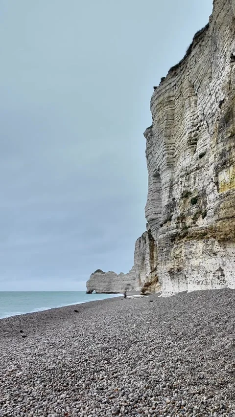 Vertical static shot of the iconic Étretat cliffs and pebble beach under an over Stockbeeldmateriaal 332860301