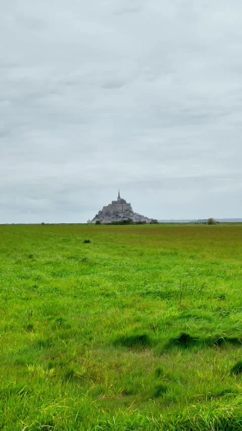 Vertical static shot of the Mont Saint-Michel Abbey towering over traditional s Vídeos de archivo 332723997