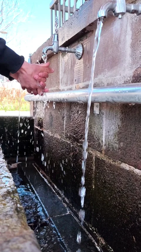 Vertical static shot of multiple streams of water flowing from antique taps into Vídeos de archivo 334660055