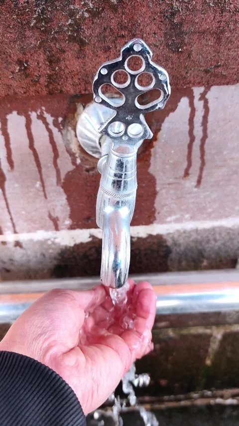 Vertical static shot of a person's palm filling with fresh water from a Vídeos de archivo 334660115