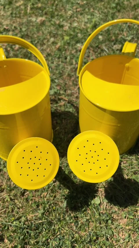 Vertical static shot of two yellow kids watering cans Stock Footage 312528701