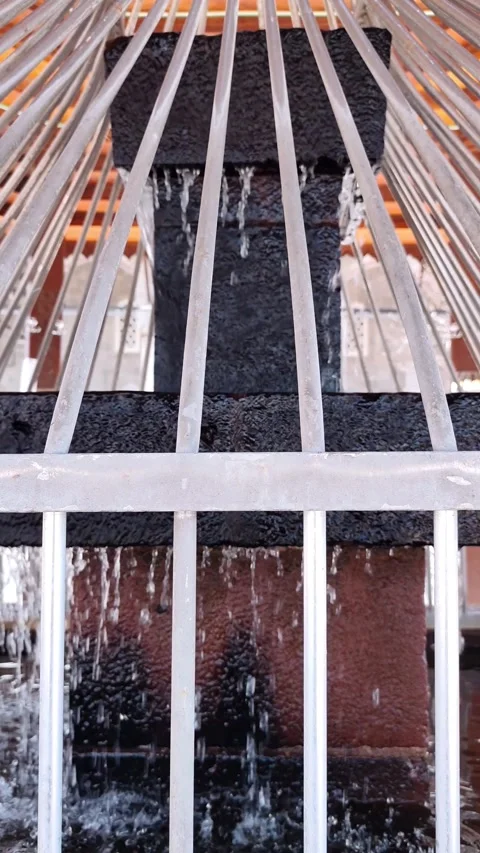 Vertical static shot of water flowing from a tiered stone fountain basin Vídeos de archivo 334660149