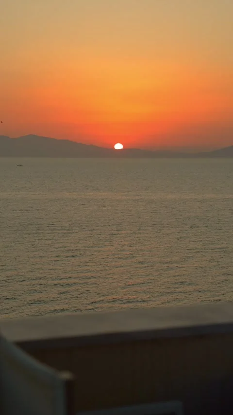 Vertical static sunset view overlooking the Aegean Sea from a terrace Stockbeeldmateriaal 347733578