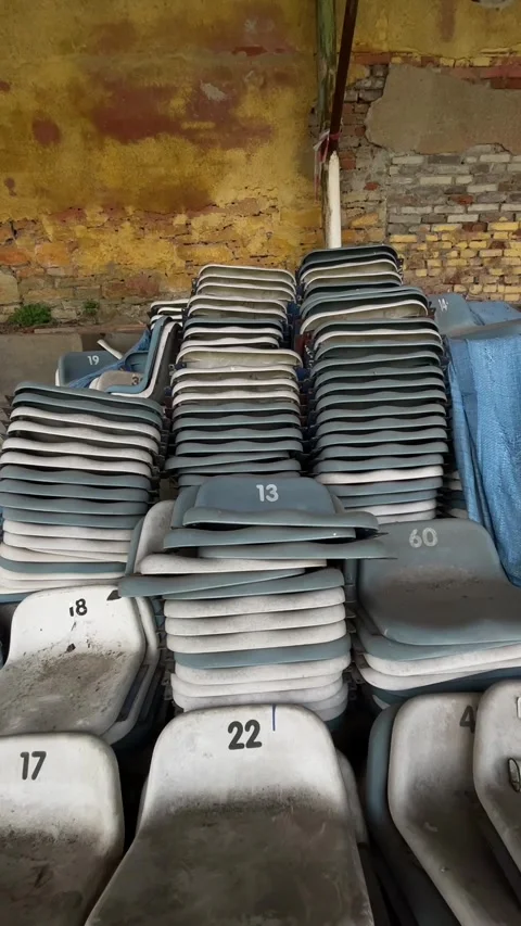 Vertical stock video stacked numbered stadium seats dusty storage Видео 347333380