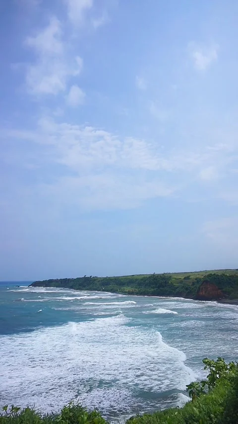 Vertical stretch of beach with blue sea water with big waves during the day Video stock 241133757