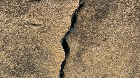 Vertical structural crack running through a textured concrete block wall Fotos Stock