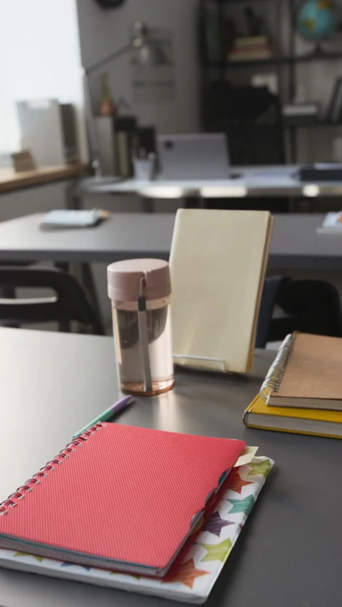 Vertical of Student Desk with Notebooks, Water Bottle Sitting in Empty Classroom Stock Footage 339654833
