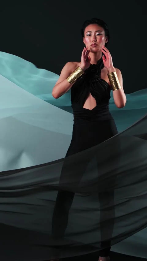 Vertical studio portrait of a young asian model in black jumpsuits and bright Stock Footage 310716216