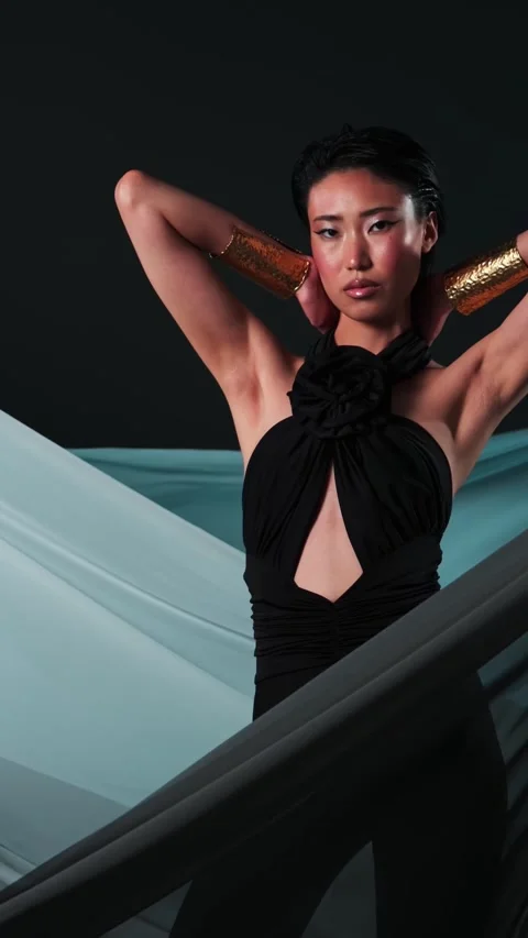 Vertical studio portrait of a young asian model in black jumpsuits and bright Stock Footage 322995920