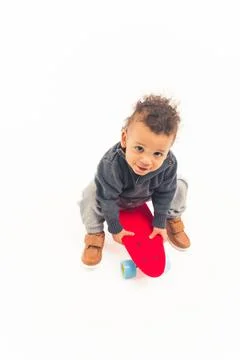 Vertical studio shot of a cute innocent biracial baby boy looking at camera and Stock Photos