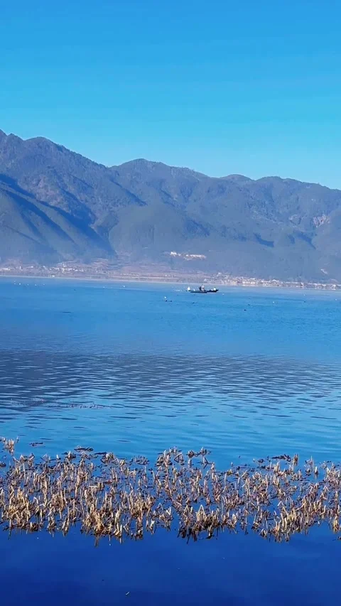 Vertical Stunning Deep Blue Water and Mountain Scenery of Lugu Lake Stock Footage 331688360