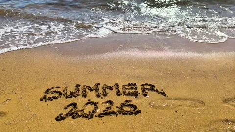 Vertical summer 2026 text on beach sand in slow motion Video stock 335758102
