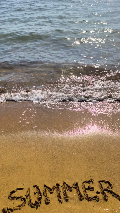 Vertical summer text on beach sand in slow motion at golden hour Video stock 335758264