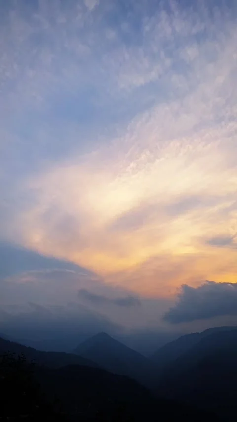 Vertical Sunset clouds moving over mountain silhouette Stock Footage 333228046