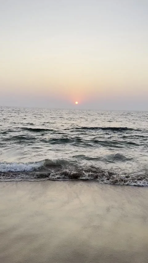 Vertical sunset over Arabian Sea waves crashing on beach in Goa India Видео 343156033