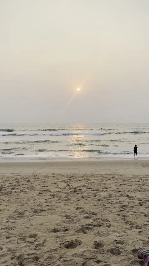Vertical sunset over Arabian Sea with silhouette person on Candolim Beach Goa 库存影片 343156053