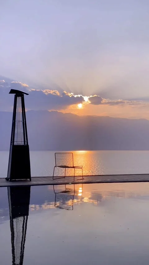 Vertical Sunset Over Erhai Lake with Empty Chair and Sunbeams 库存影片 333488320