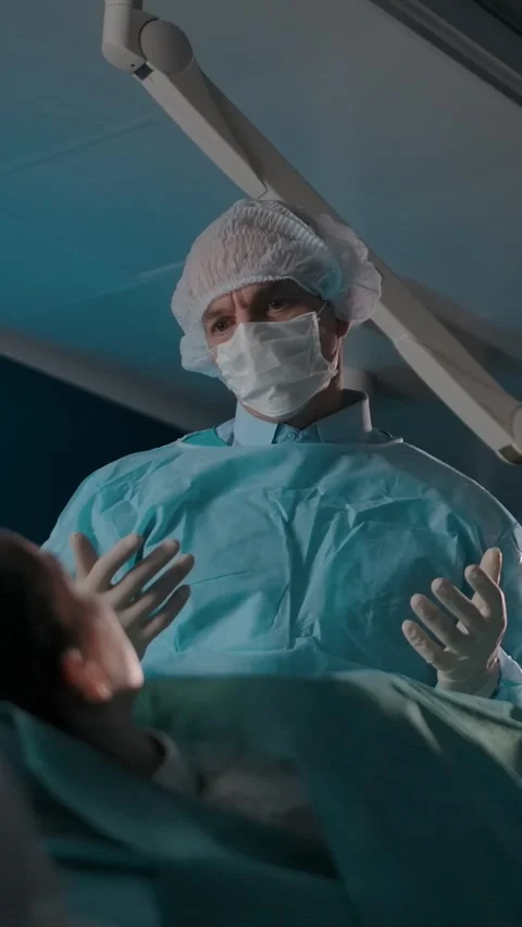 Vertical of Surgeon explains treatment plan for patient on operating table Stock Footage 276804772