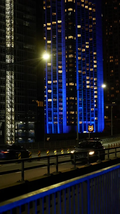 Vertical Sydney traffic passes neon blue skyscraper 6K Stock-Footage 310380330