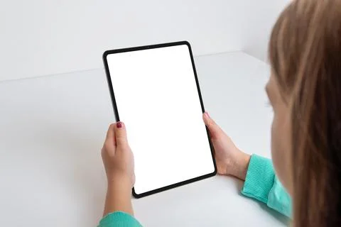 Vertical tablet held by a girl on a work desk Stock Photos