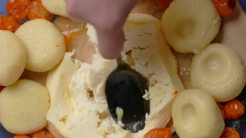 Vertical tabletop food video: chef mashes baked feta cheese and mix it with Video stock 180981513