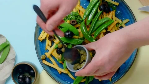 Vertical tabletop video: chef adds capers to the fried potato dish Stock Footage 180573549