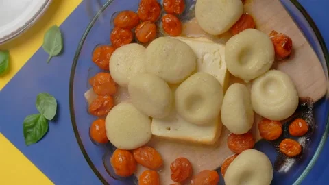 Vertical tabletop video: chef adds cooked potato dumplings to the baked tomatoes Stock Footage 180943954
