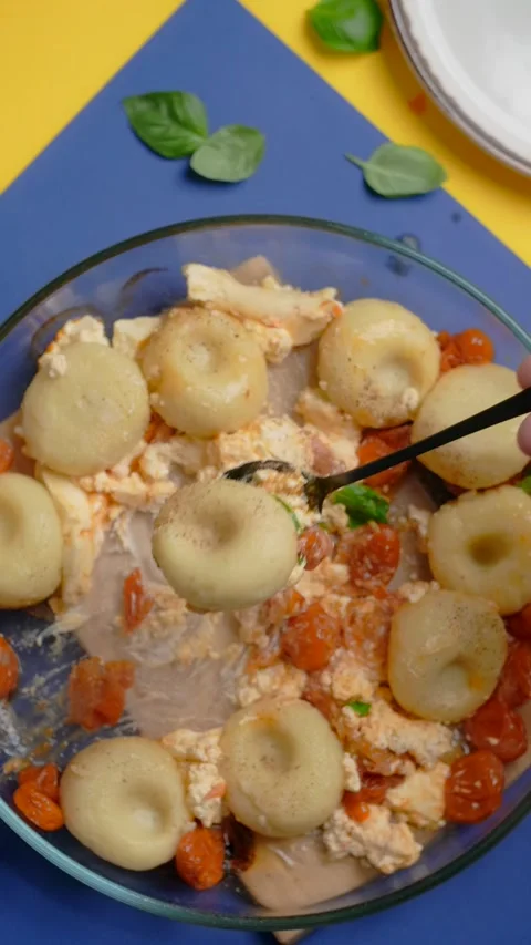 Vertical tabletop video: chef takes cooked potato dumpling with tomatoes and Stock Footage 179559869