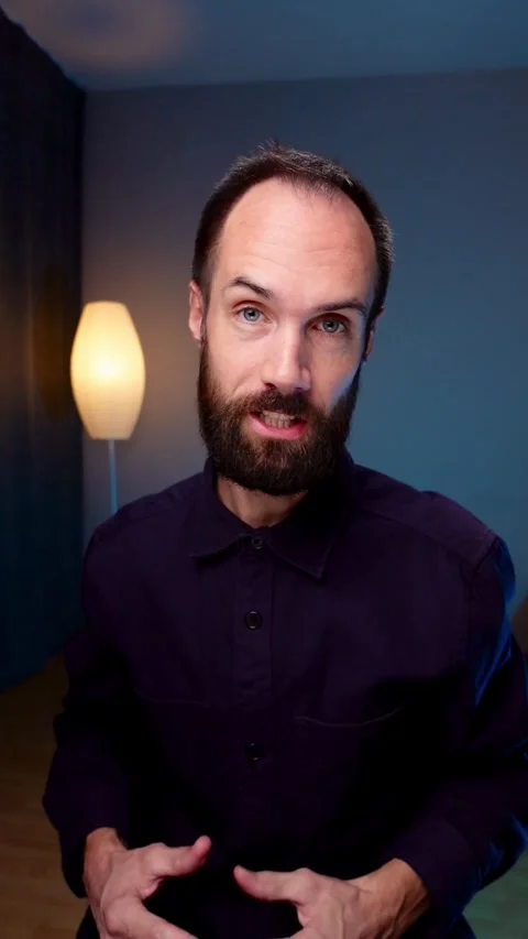 Vertical Talking Head Video of a Man in a Dark Shirt Speaking to Camera Indoors Stock Footage 291083233