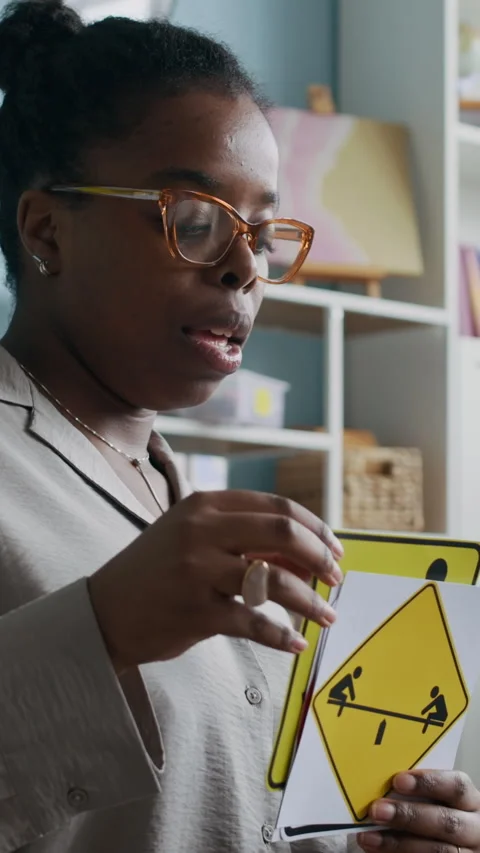 Vertical of Teacher Using Visual Aids to Teach Young Students Traffic Symbols Stock Footage 312591544