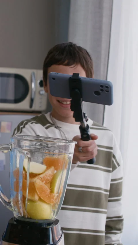 Vertical of Teens Recording Smoothie Tutorial Video with Phone in Kitchen 動画素材 331571992
