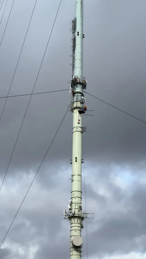 Vertical. Telecommunications mast climber lifting up metal ladder in a hoist. Stock-Footage 331305989