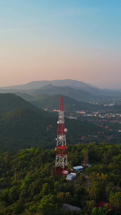 Vertical telecommunications tower on the mountain while a beautiful sunset Stock Footage 297040265