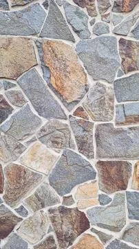 Vertical texture of irregular stone wall made from multicolored granite Stock Photos