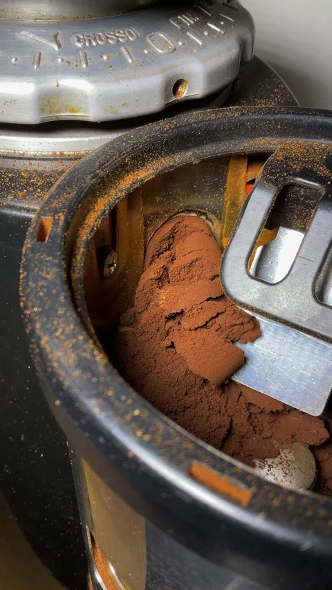 Vertical - A thick flow of ground coffee exiting the chamber of a grinder. Stock-Footage 281946610