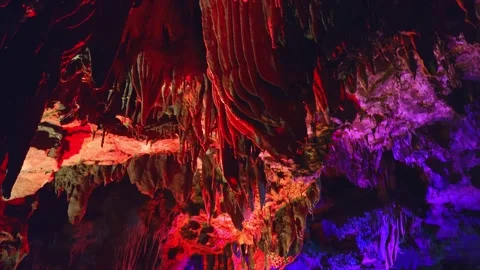 Vertical Tilt Down of Illuminated Stalactites in Yellow Dragon Cave of Видео 336742851