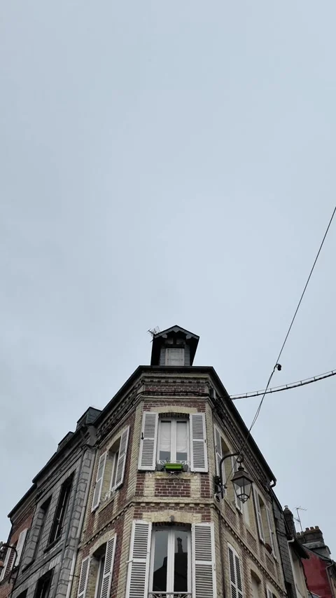 Vertical tilt-down shot revealing a classic brick corner building with white shu Vídeos de archivo 332860454