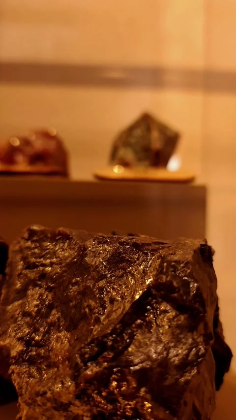 Vertical tilt-down shot showcasing a dark, metallic raw ore with crystalline Vídeos de archivo 334109022