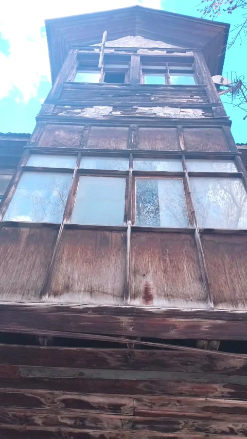 Vertical tilt down shot showcasing the textured, decaying facade of a Vídeos de archivo 334660071