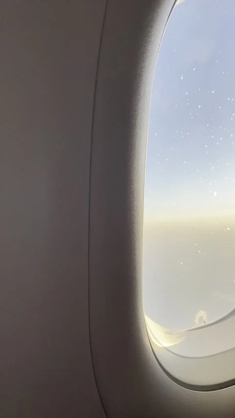 Vertical tilt up shot looking through airplane window at winglet Video stock 338403908